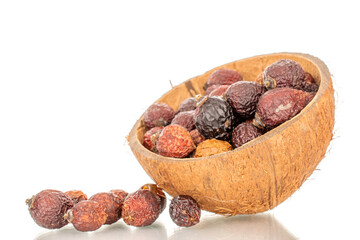 Several dry rosehip berries in a coconut shell, macro, isolated on white background.