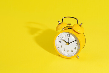 stationery, apple and retro alarm clock on a bright yellow background