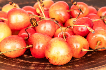 Organic ripe cherry berries on a clay dish.