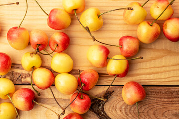 Several sweet cherry berries on a wooden table, macro, top view.