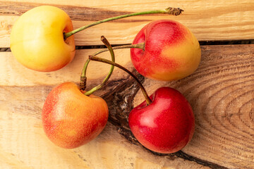 Several cherries on a wooden table, macro, top view.