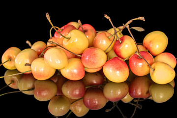 Several sweet cherry berries, macro, isolated on black background.