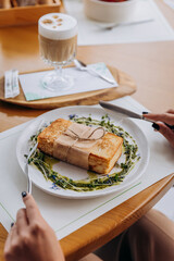 Close up of woman eating tasty sandwich with ham and cheese. Breakfast restaurant menu
