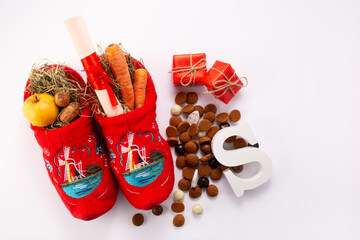 Dutch children shoes filled with treats, traditional sweets pepernoten and chocolate letter for St Nicholas Day