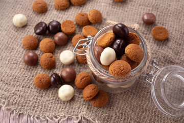 Pepernoten cookies in glass jar on sackcloth. Traditional sweets for St. Nicholas Day