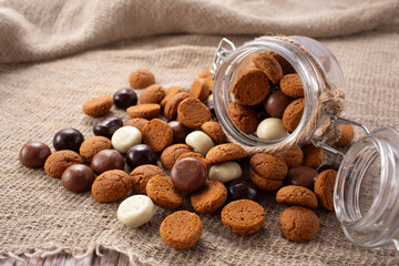 Pepernoten cookies in glass jar on sackcloth. Traditional sweets for St. Nicholas Day