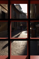 Donna che cammina in controluce e vista attraverso una finestra rossa