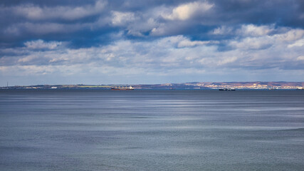 Teleaufnahme der entfernten Kreidek&uuml;ste Jasmund &uuml;ber der ruhigen Ostsee mit Frachtschiffen am Horizont unter Wolken, Sellin, Vorpommern-R&uuml;gen, Mecklenburg-Vorpommern, Deutschland