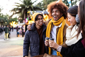 Happy young diverse friends enjoying winter holidays. Millennial people having fun during christmas trip in european city. - obrazy, fototapety, plakaty