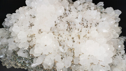 Rock crystal druse with pyrite inclusions. white quartz with pyrite close-up on a black background....