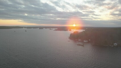 Regular image of a water surface during day with a beautiful sky and the sun