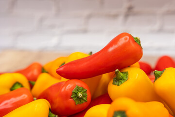 delicious and healthy red, orange and yellow sweet peppers on a wooden cooking board ready to be prepared in one recipe
