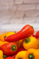 delicious and healthy red, orange and yellow sweet peppers on a wooden cooking board ready to be prepared in one recipe