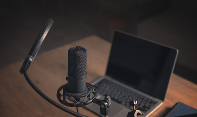 Interior of a home studio for podcasts. Large black Microphone, notebook and notebooks on table. Interior. Closeup