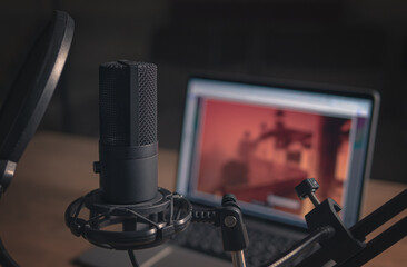 Home studio for podcasts. Large Microphone, laptop and notebooks on the table. Close-up. Cinematic...