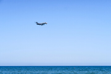 Fototapeta na wymiar the plane lands over the sea, the beach. The plane flies over the beach umbrellas