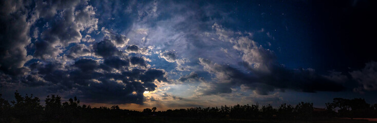 Panorama of the night sky with clouds and stars