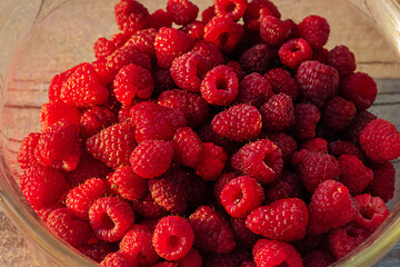 Raspberries in a glass bowl close-up. Berries of red ripe raspberries.