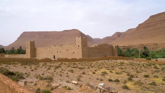 Traditional Moroccan fortress made out of clay with high clay walls in the Atlas mountain gorge by Ziz river, Morocco