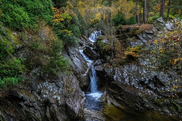 Landscape of Falls of Bruar Waterfall with mossy rocks in Scotland