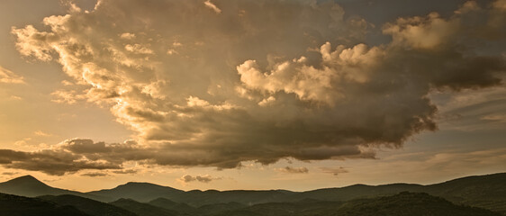 Les derniers rayons du soleil embrassent tendrement les montagnes de Montbrun les Bains, créant...