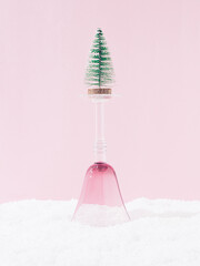 Upside down drinking glass the snow with a Christmas tree on top. Creative surreal Christmas, New...