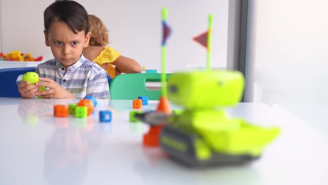 Elementary School student studying technology, using joystick control panel with automatic remote car toy. Coding, programming basis for kids