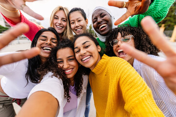 Multiracial young group of women having fun together taking selfie portrait. Joyful millennial...