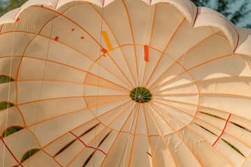 Very close up photo of open parachute, just after landing. Sunny day, blurry tropical...