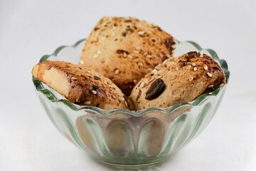 Freshly baked chocolate chips cookies scattered on white background.