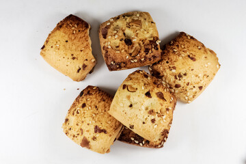 Freshly baked chocolate chips cookies scattered on white background.