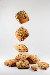 Freshly baked chocolate chips cookies scattered on white background.