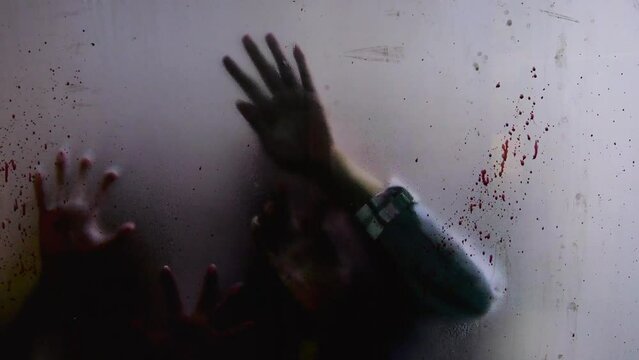 Out-of-focus infected zombie hands claw at bloodied window, signaling apocalypse. Haunting video, encapsulating dread and chaos of apocalypse. Concept terror of apocalypse looms, undead scratch glass