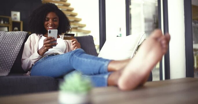Credit card, phone and woman relax on sofa with ecommerce, sale or bank, password and payment at home. Smartphone, app and person with feet up in living room for online shopping, sign up or survey