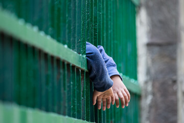 Child hands holding thick bars