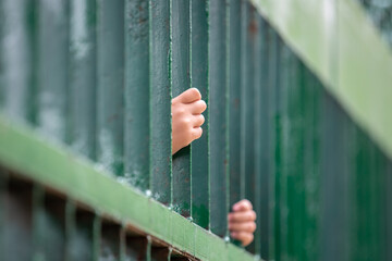 Child hands holding thick bars