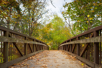Fototapeta na wymiar Old footpath bridge close-up view on an autumn day, Charles River Greenway, Watertown, Massachusetts, USA