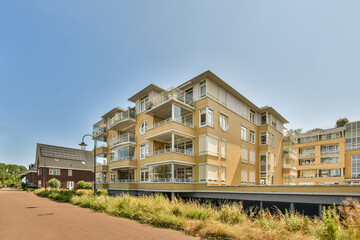 an apartment building on the side of a road with plants and flowers growing in the fore - swayr area