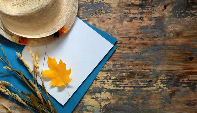 Chapeau de paille et feuille d'automne sur fond bois rustique