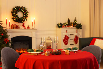 Cozy living room with Christmas tree near fireplace and table served for celebration. Interior design