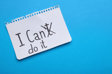 Motivation concept. Changing phrase from I Can't Do It into I Can Do It by crossing out letter T on light blue background, top view. Space for text - obrazy, fototapety, plakaty