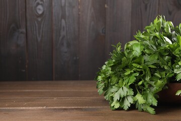 Bunch of fresh parsley on wooden table, space for text