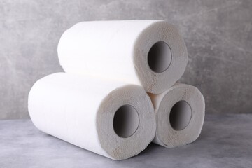 Rolls of paper towels on grey table, closeup