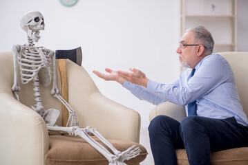 Old male psychologist meeting with skeleton