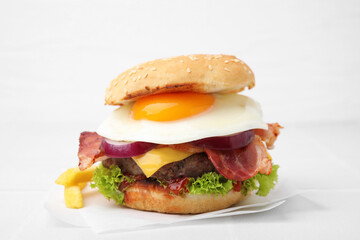 Delicious burger with fried egg on white table, closeup