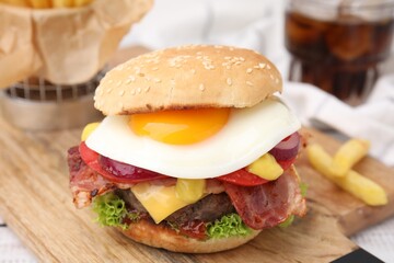Delicious burger with fried egg on table, closeup