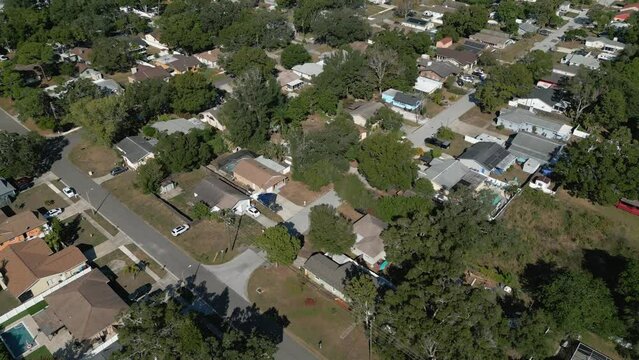 Single family homes are shown in a flyover view in real time during the late afternoon in a Florida neighborhood.
