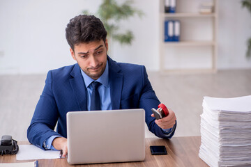 Young male employee and too much work in the office