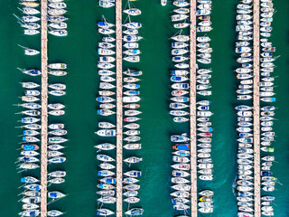 Aerial top view of boats and yachts in marina from above. Yacht parking, A marina lot, Yacht and sailboat is moored at the quay, Aerial view by drone.