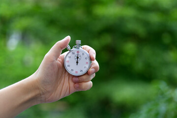 People hand holding stopwatch outdoors